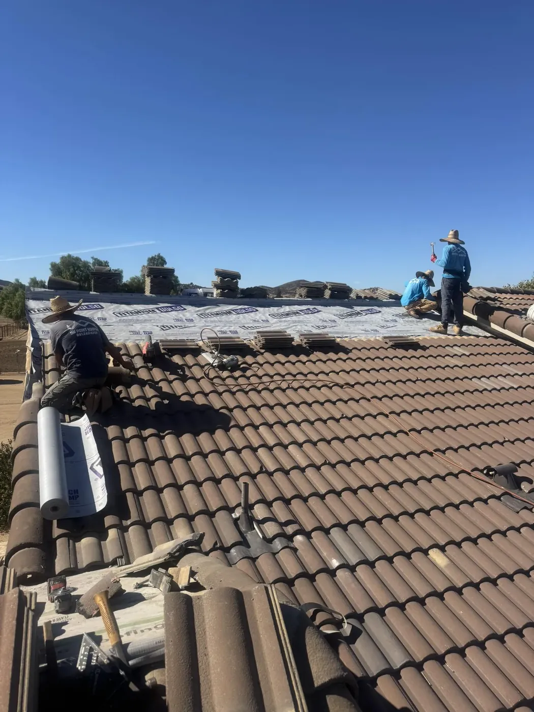 Roofing crew replacing broken tiles on a Wildomar, CA home